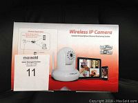 Front view of sealed box showing Wireless IP Camera with wifi and audio logos, smartphone monitoring images, product branding.