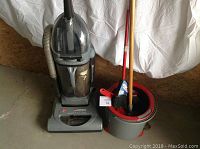 Full view of Hoover WindTunnel vacuum, broom, mop, and mop bucket grouped together