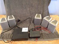 Full set of speakers and wireless unit boxes displayed on towel
