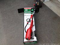 Full view of the Craftsman electric trimmer on top of its original box showing the main unit with cord and handle.