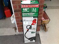 Front view of the sealed box showing Craftsman branding and product specifications 16 inch cutting path, 9.3 amp power.