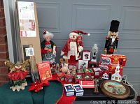 Full view of vintage and new Christmas decorations including figurines, boxed ornaments, outdoor lights, angel wings, and nutcracker.