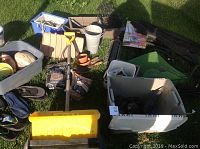 Overall view of garden supplies including tools, pots, totes, bags of smoker chips, sports balls, and yellow push shovel.