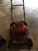 Front angled view of red mower with visible Toro logo and push handle