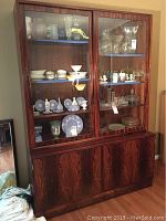 Front view of the china cabinet showing sliding glass doors and contents (not included) inside.