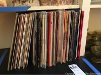 Photo showing a large collection of vinyl records standing upright with various album covers visible.