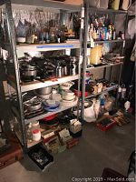Metal shelving units filled with kitchenware and household items, showing general structure and shelf spacing.