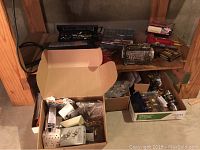 Wide shot showing shelves with multiple boxes of assorted tools and hardware including electrical parts and door hardware items.