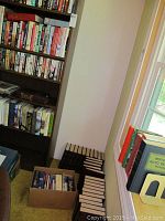 Shelves and boxes filled with various books, including large encyclopedia volumes and assorted novels.