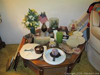 Photo showing full table with all items including vases, glassware, serving dishes, faux flowers, flags, candles, ornaments, and decorative key.