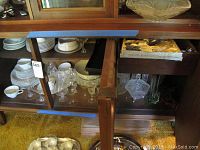 Cabinet with Rosenthal Selb Fossberg Bavaria china arranged inside, with plates, bowls, cups, stemware, glassware, and silver serving pieces.