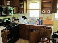 Kitchen counter and cabinets with various kitchen items boxed and arranged