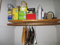 Shelf with boxed cleaning and household items, light bulbs, and hangers