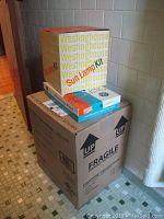 Stacked boxes including Westinghouse Sun Lamp Kit box on top, GE heating pad box in middle, and large Eden Pure portable heater box on bottom.
