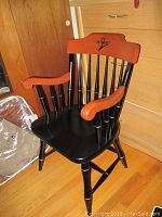 Wooden chair with armrests and backrest branded 'Internet Z', painted black with natural wood armrests