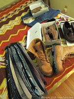 Photo showing men's footwear including Lehigh 100 boots, Quiland shoes, Sperry shoes plus assorted ties and denim vest