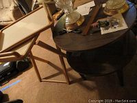 Photo of round wooden side table with two tiers and TV tray with stand, items showing wear, chips, and scratches.