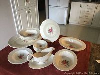 Overall lot arranged on table showing plates stacked at back, bowls at front, gravy boat and serving dishes