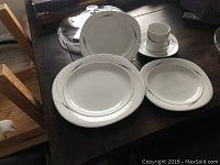 Photo of white Mikasa Caviar place setting including coffee cup, saucer, dinner plate, salad plate, and soup bowl with silver trim.