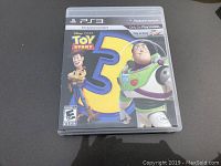 Front cover of Toy Story 3 PS3 game showing Woody and Buzz Lightyear with large number 3.