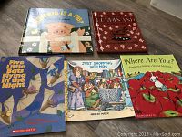Photo shows five children's books laid out flat: two hard cover ('How Big is a Pig?' and 'Ferdinand') and three soft cover Scholastic books ('Five Little Bats Flying in the Night', 'Just Shopping with Mom', 'Where Are You?').
