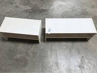 Two white shoe racks side by side on grey concrete floor, showing size difference, both are rectangular open-front racks