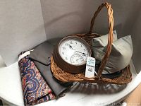 Wicker basket holding round clock and fabric pieces