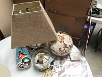 Full view of the shell collection including lamp, fish bowl with shells, candle holder, and folded beach towel
