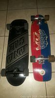 Top view of two skateboards, one black Santa Cruz and one red/blue Kryptonics with flame graphic, showing decks and wheels