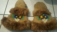 Front view of pair of antique Native American mittens with colorful beadwork and fur cuffs