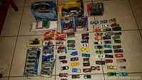 Full overview of the die cast car lot showing boxed and loose vehicles arranged on floor