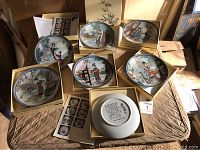 Overview of all seven plates in individual presentation boxes with one plate flipped to show Chinese script on back