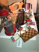 Full view of lot with vintage gumball machine, games, and piggy bank on table