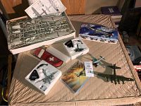 Overview photo of airplane models and model kit parts laid on a surface, with instruction manual and model box in background.