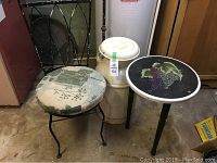 Photo showing all three items: vintage milk can, small round table with grapevine design, and metal chair with floral cushion.