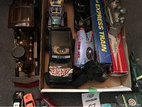 Photo showing a box of various vintage and retro toy vehicles including a steam train, Nikko branded toy car, and boxes labeled 'EXPRESS TRAIN' and toy parts.