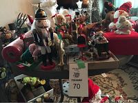 Overview photo of Christmas lot including nutcracker, figurines, reindeer, bells, and other decorations on table