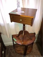 Two-tier half-moon shaped wooden table with turned pedestal and curved legs