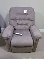 Front view of light brown Pride power lift chair with attached wired remote on seat.