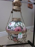 Assembled lamp hung by chains showing shade, gallery and font