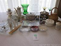 Wide view of all assorted china, pottery, crystal, and other items displayed on table