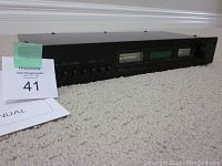 Front and manual view of Magnum Dynalab FT-11 FM tuner showing unit and included manual.