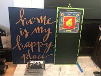 Two pieces of wall art: one with phrase 'home is my happy place' and one a decorative chalkboard with pear design.