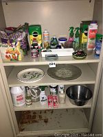 Photo of shelving unit with two platters, multiple pet care bottles, gardening products, metal bowl, and assorted small items.