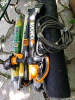 Photo of Worx electric garden blower and multiple rolls of weed block fabric on the ground