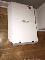 Closed white Frontpoint system box with 'Let's Begin' instruction visible.