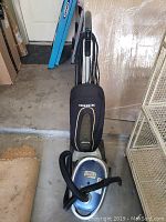 Full view of Oreck upright vacuum with canister vacuum beside it showing overall condition and setup