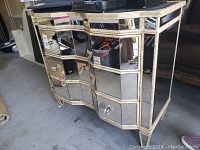 Front and side view showing mirrored panels and missing drawer handles, overall structure and detailing visible.