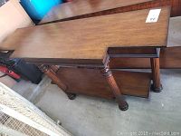 Full side view of the wooden entry table showing rectangular top and four carved legs.