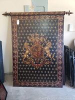 Front view of the large rectangular wood wall panel with heraldic black, gold, and red design including lions, fleur-de-lis, and crest.